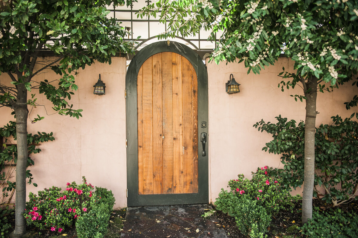 Arched Iron Door with Vertical Wood Accents in a Spanish Style Home in Santa Clara