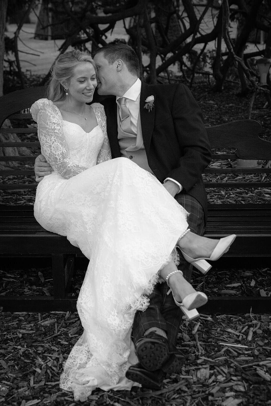 Bride and Groom kiss on a bench at Prestonfield House