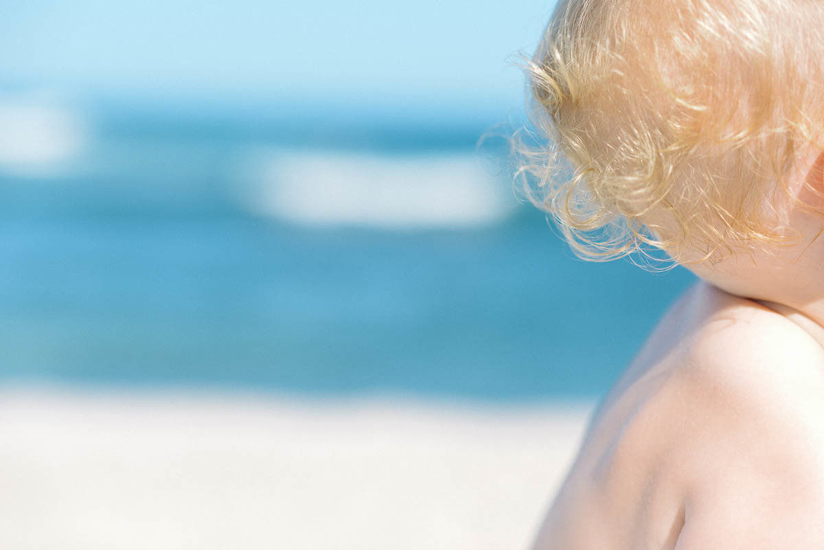 blonde baby ringlets with beach background