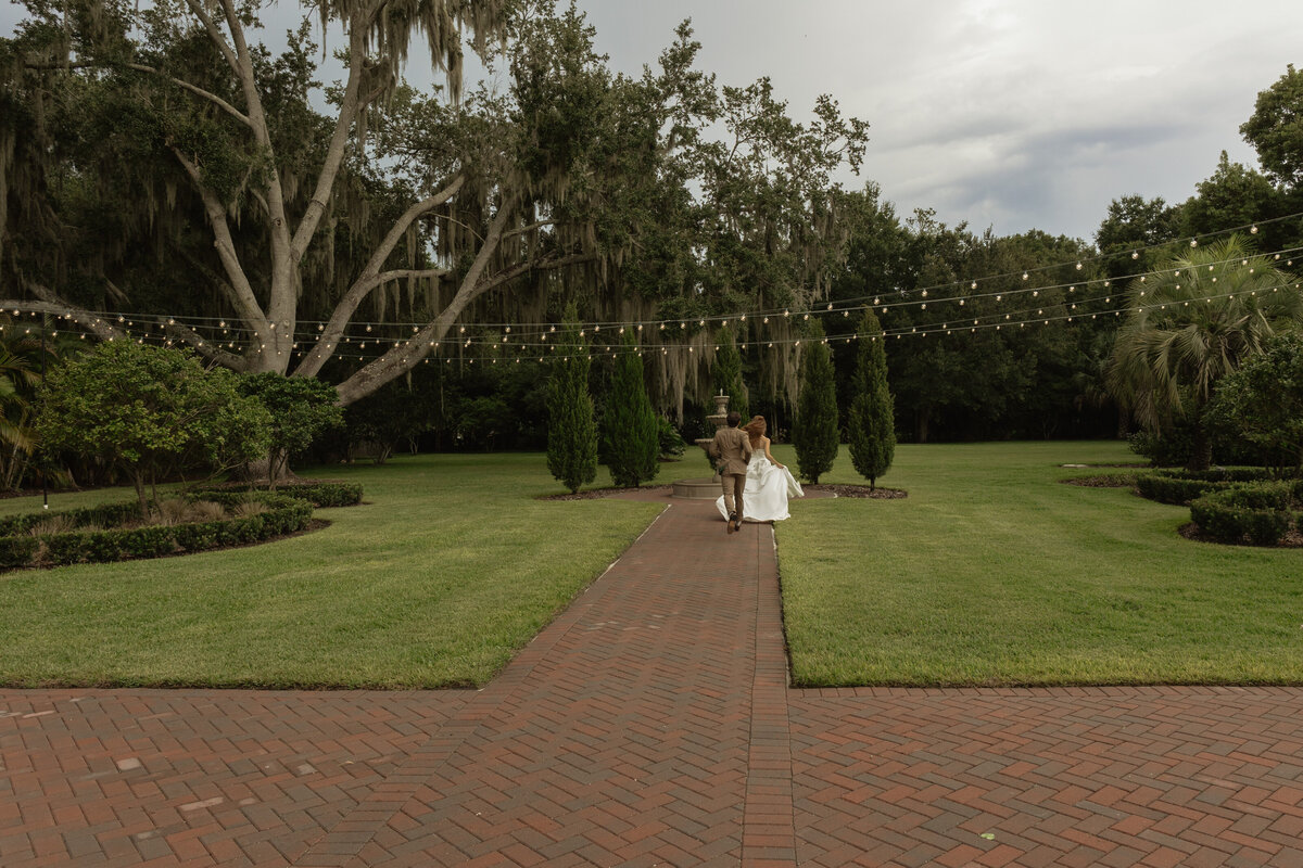 Romantic backyard wedding at The Palm Mansion in Umatilla, Florida with lush palm trees and floral arch