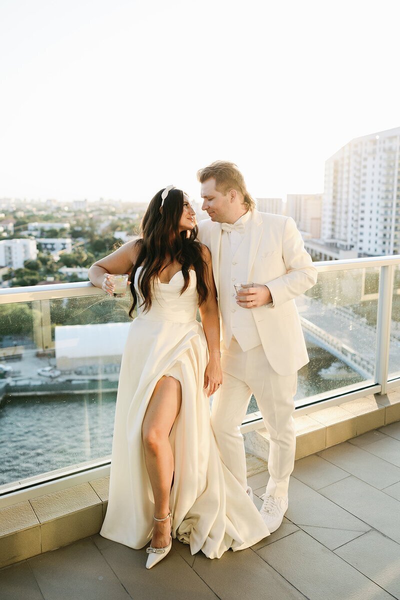 bride and groom looking at each other on balcony at penthouse at riverside wharf​