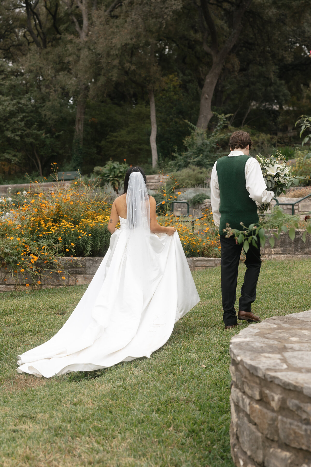 bride and groom walk through a garden in austin texas 