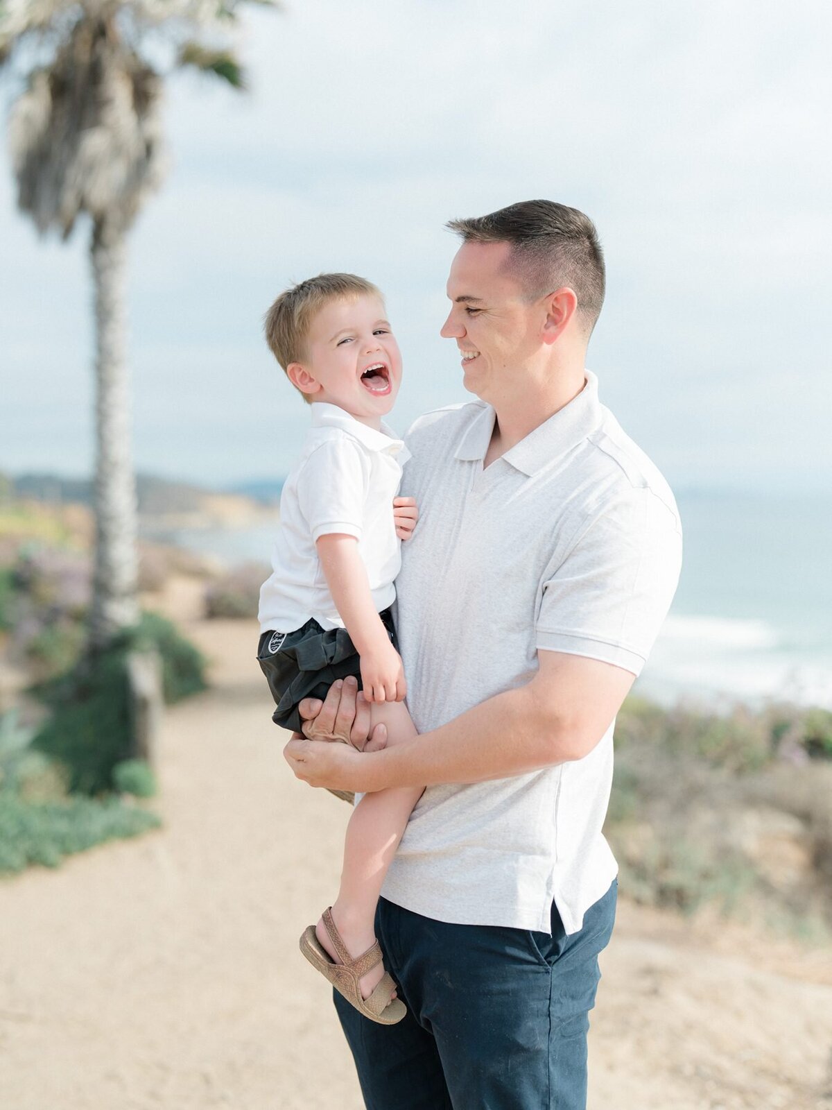 Father and son laughing during photoshoot in San Diego beach