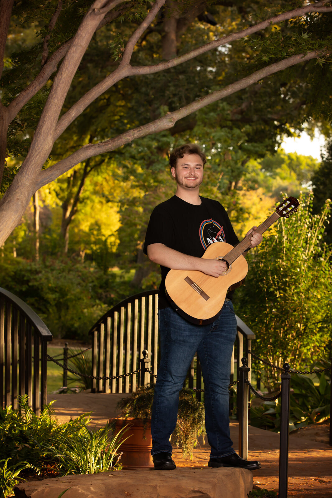 senior-boy-holding-guitar-under-trees