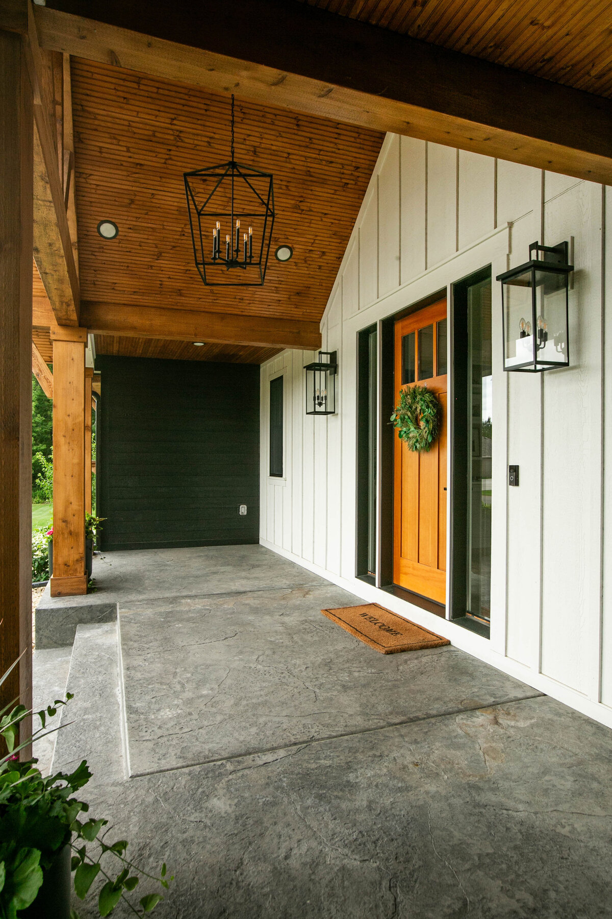 Exterior view of custom home in Otsego, Minnesota with modern wood details and front porch built by Cornerstone Custom Builds