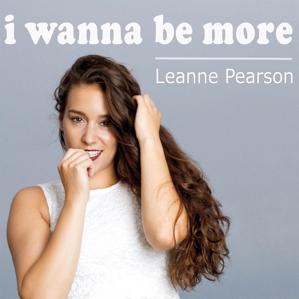 Nashville Country Music Single Title I Wanne Be More Artist Leanne Pearson standing against grey backdrop hand to her mouth biting guitar pick other hand in her hair