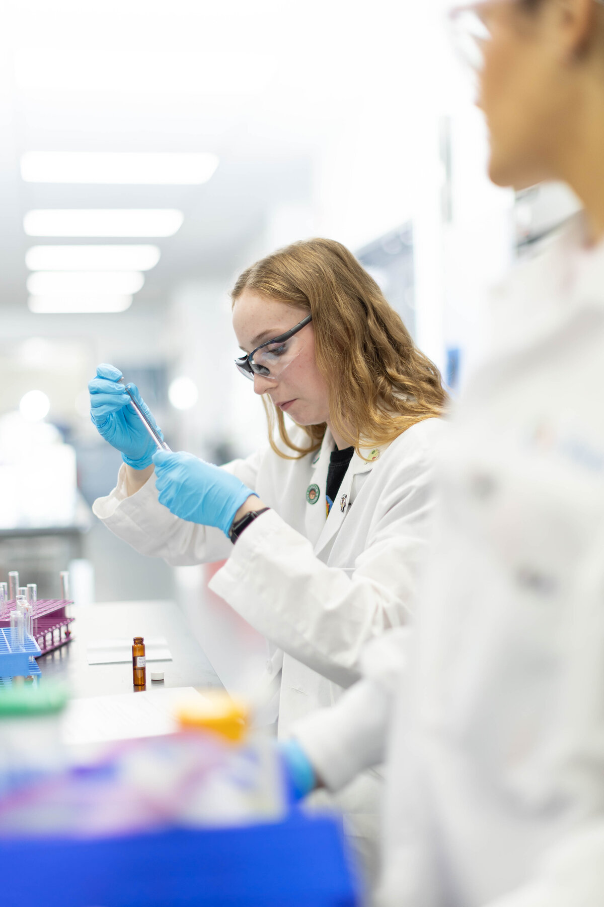 Woman dropping liquid into a test tube in a lab