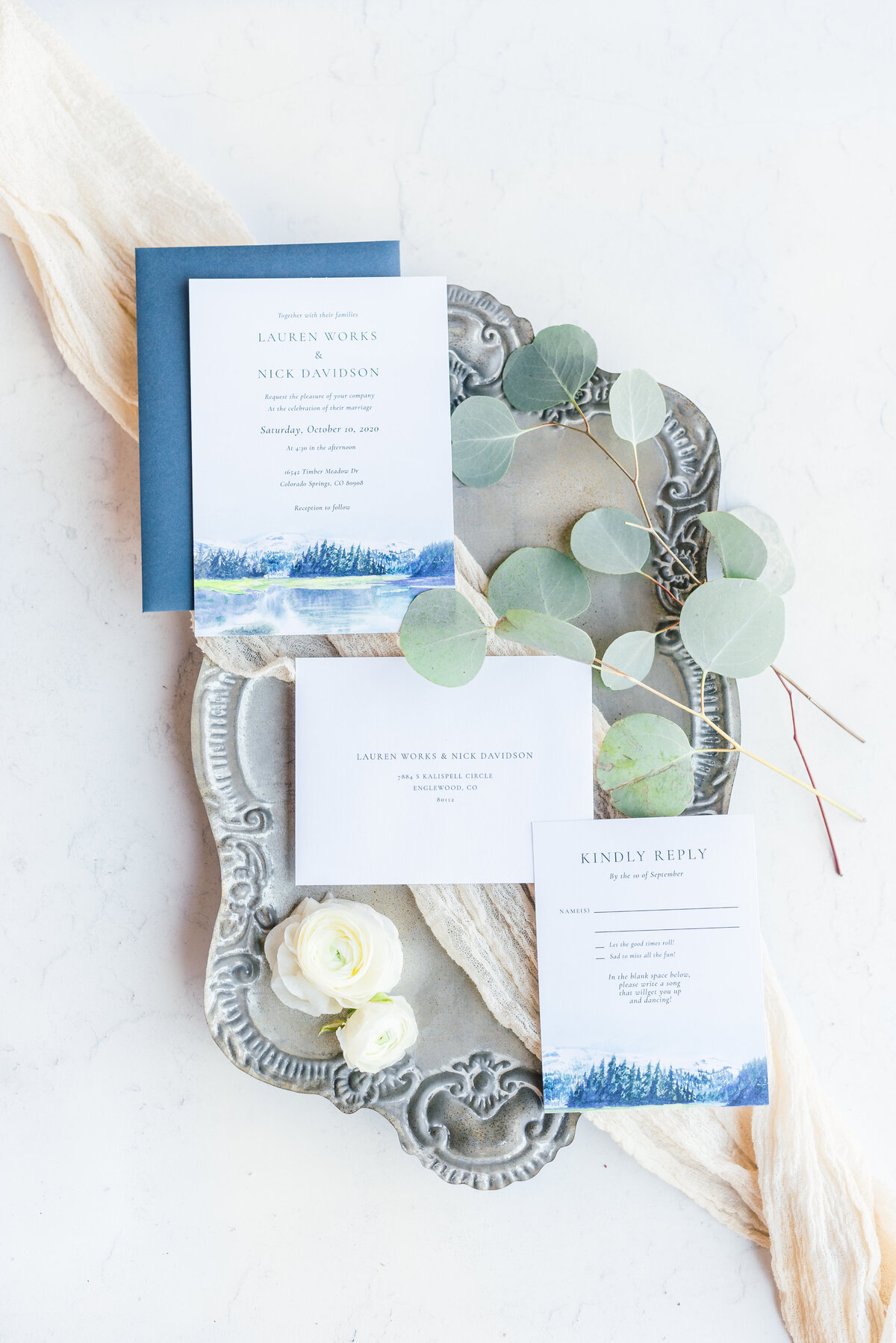 wedding invitation suite flatlay blue mountain set on a vintage tray