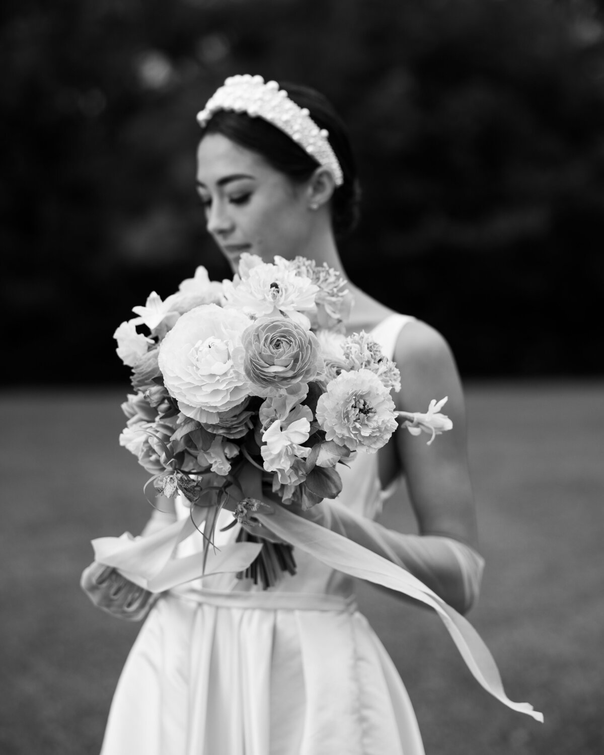 Black and white photo of the bride and flower, capturing a soft and quiet moment, captured in a candid wedding photography style — Carmel wedding photography by Kate Winters Photography.