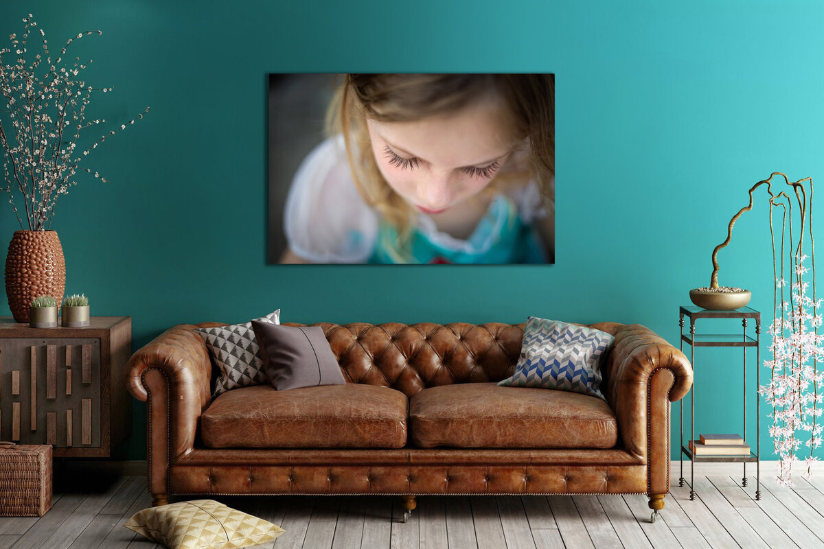 close up of little girls eyelashes framed on turquoise wall