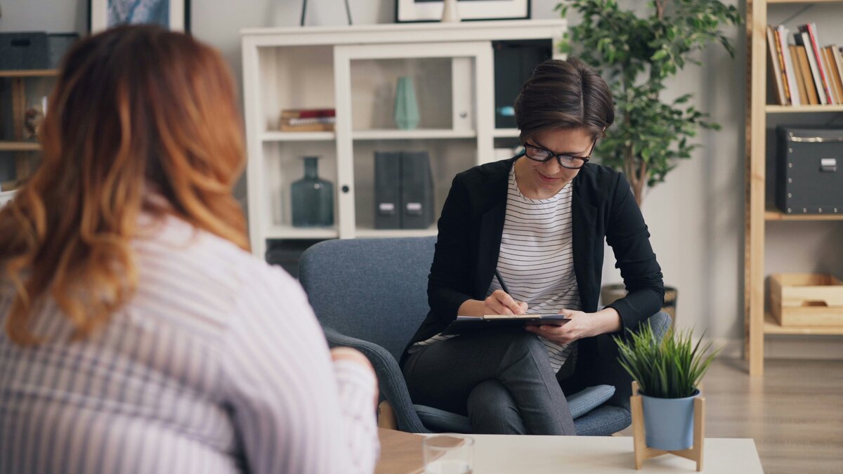 Two people talking while one takes notes on a clipboard