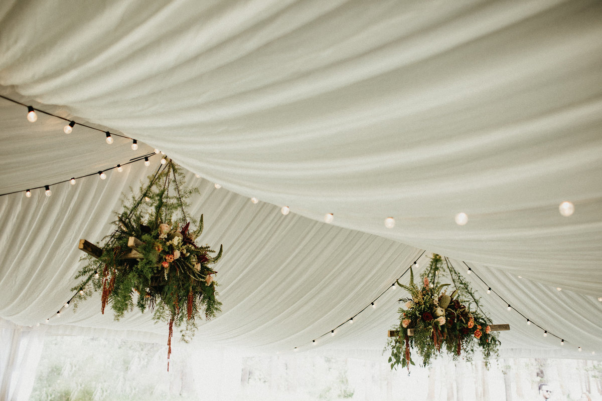 Tahoe Wedding Planners hanging   burgundy blush flowers in tent at summer wedding venue Mitchell's Mountain Meadows Sierraville near Truckee, Joy of Life Events image by Lukas Koryn