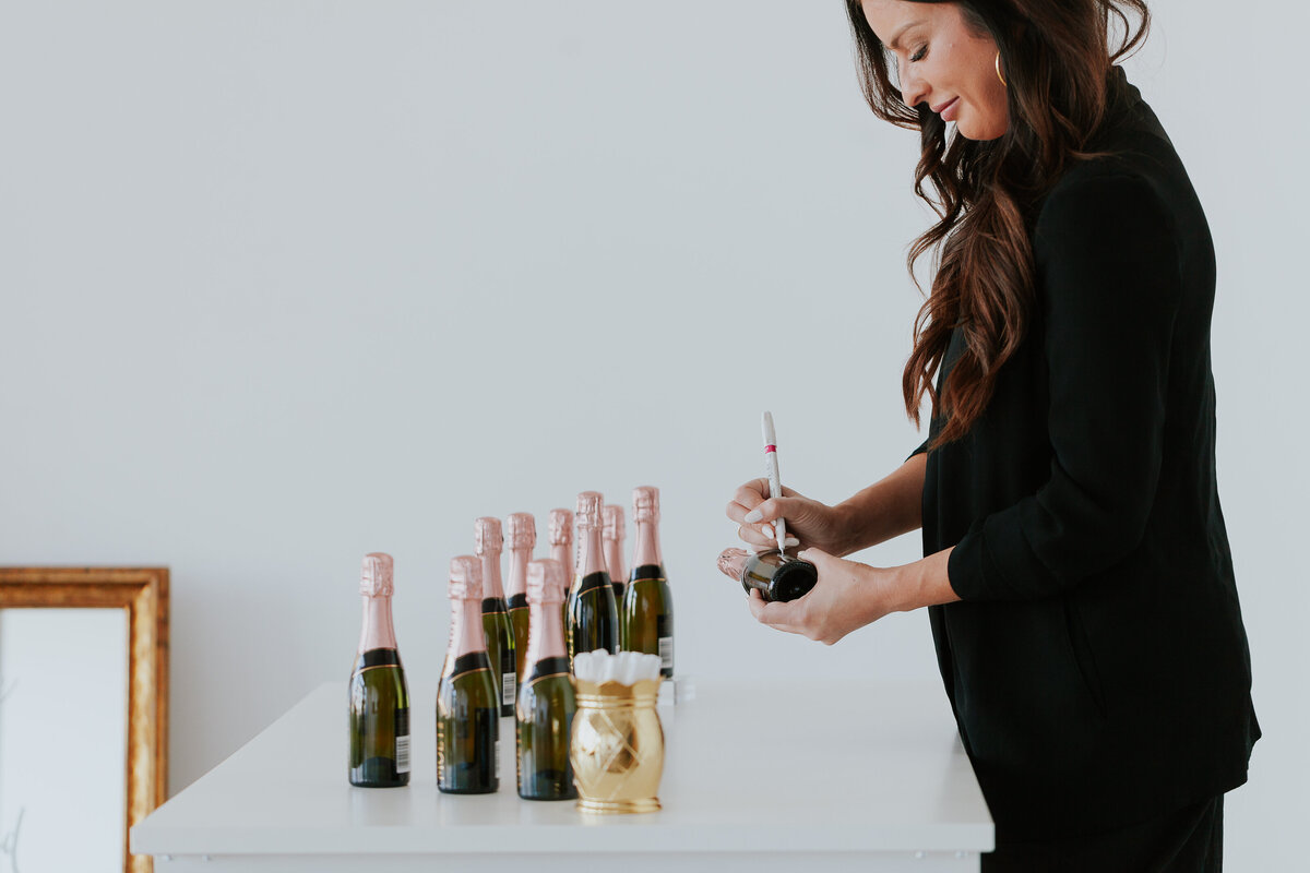 calligrapher-writing-on-mini-charmpagne-bottles-for-barnd-session-the-frame-charlotte