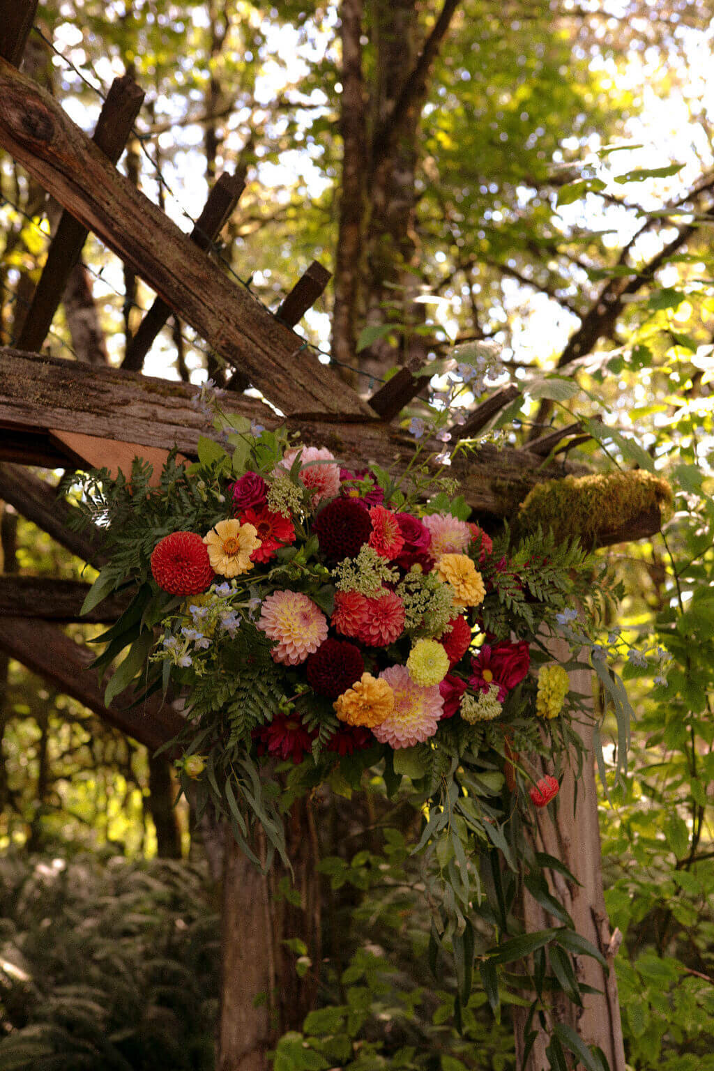 A flower installation on a wooden arbor at the Thyme Garden wedding venue.