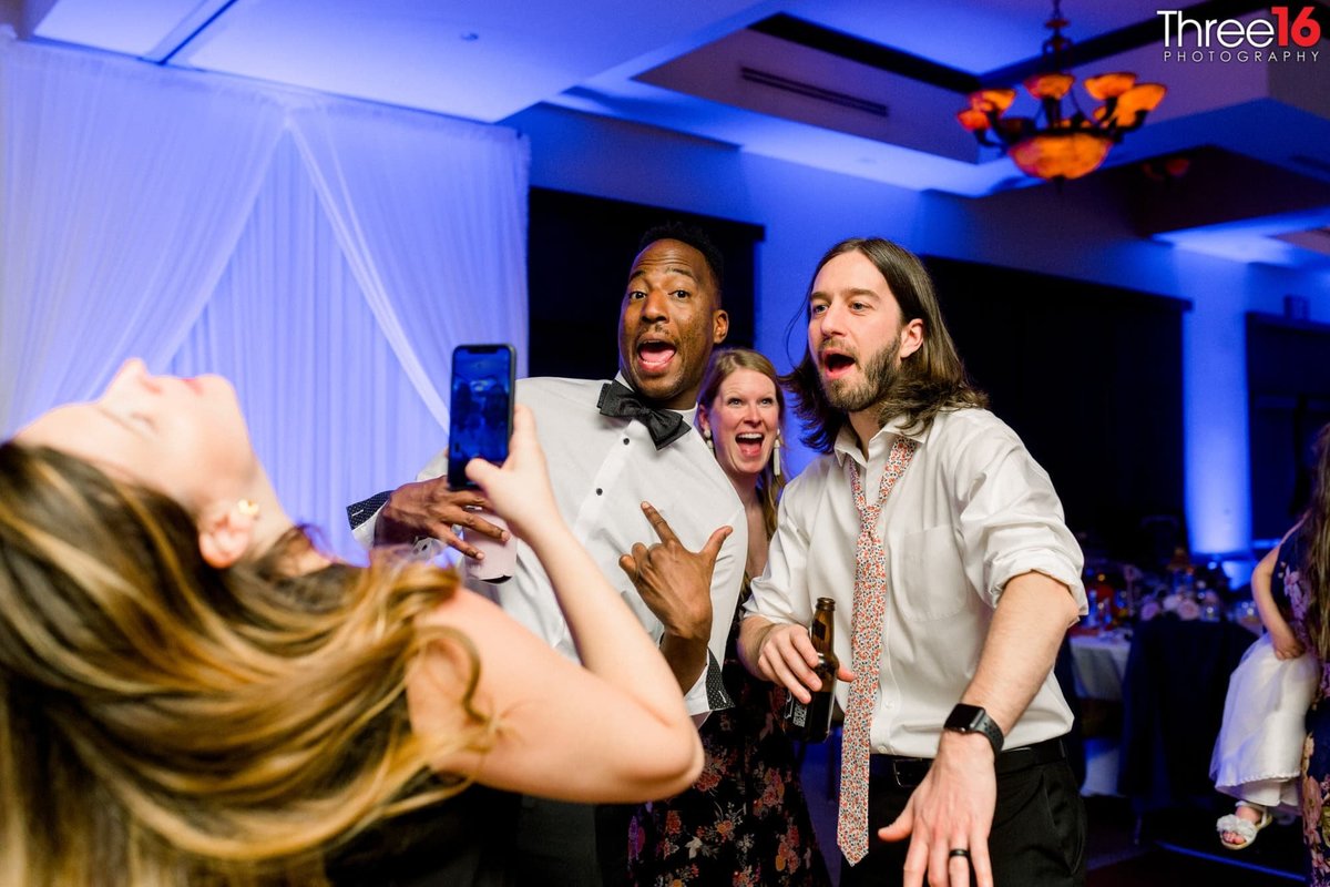Guests pose for a cell phone photo on the dance floor