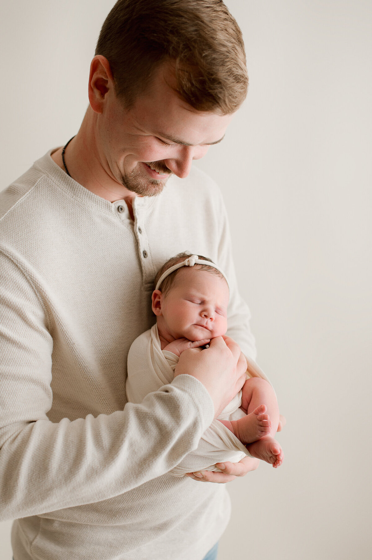 Dad holding newborn son baby photography