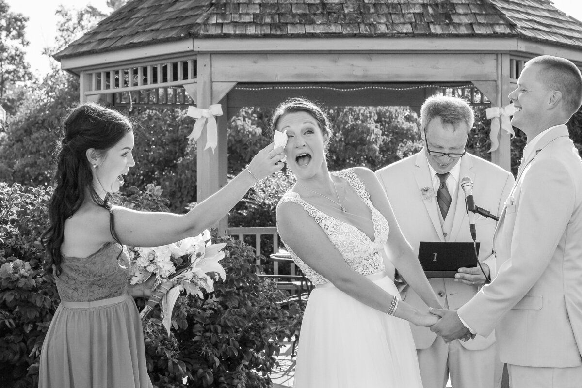 Maine of honor wiping bride's tears