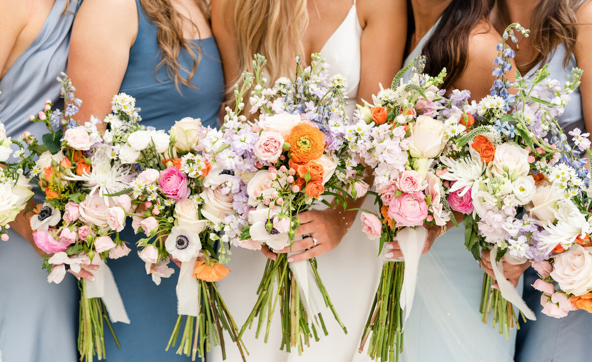 Bride and bridesmaids colorful bouquets on wedding day at Zedler Mill