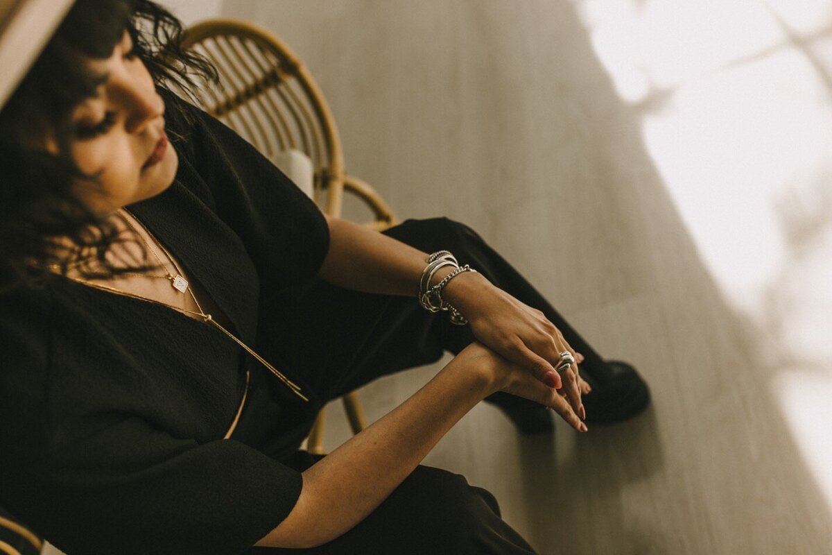 dark haired woman looking down at her hands