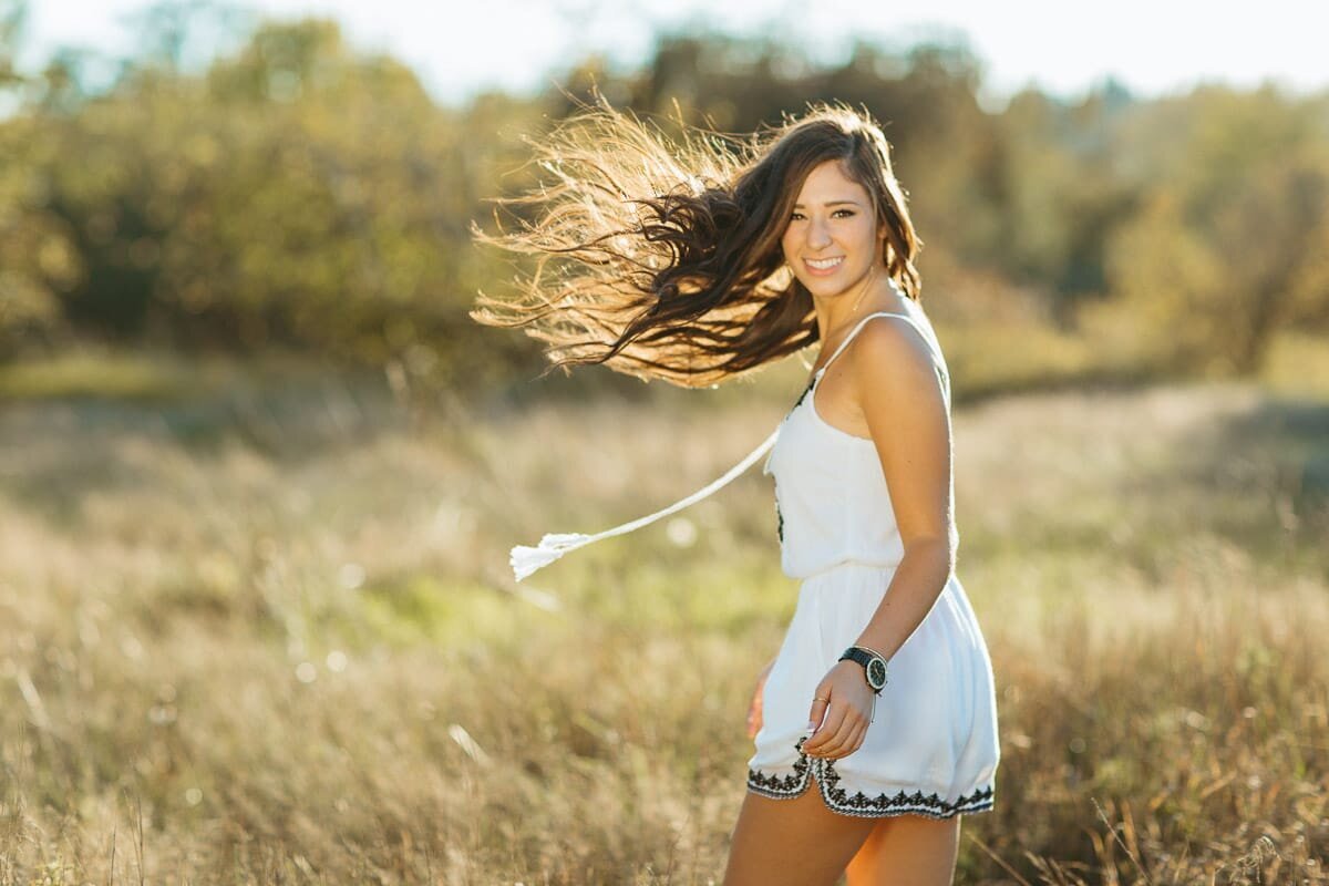 High school senior twirling in a field at sunset at Marymoor Park in Redmond.