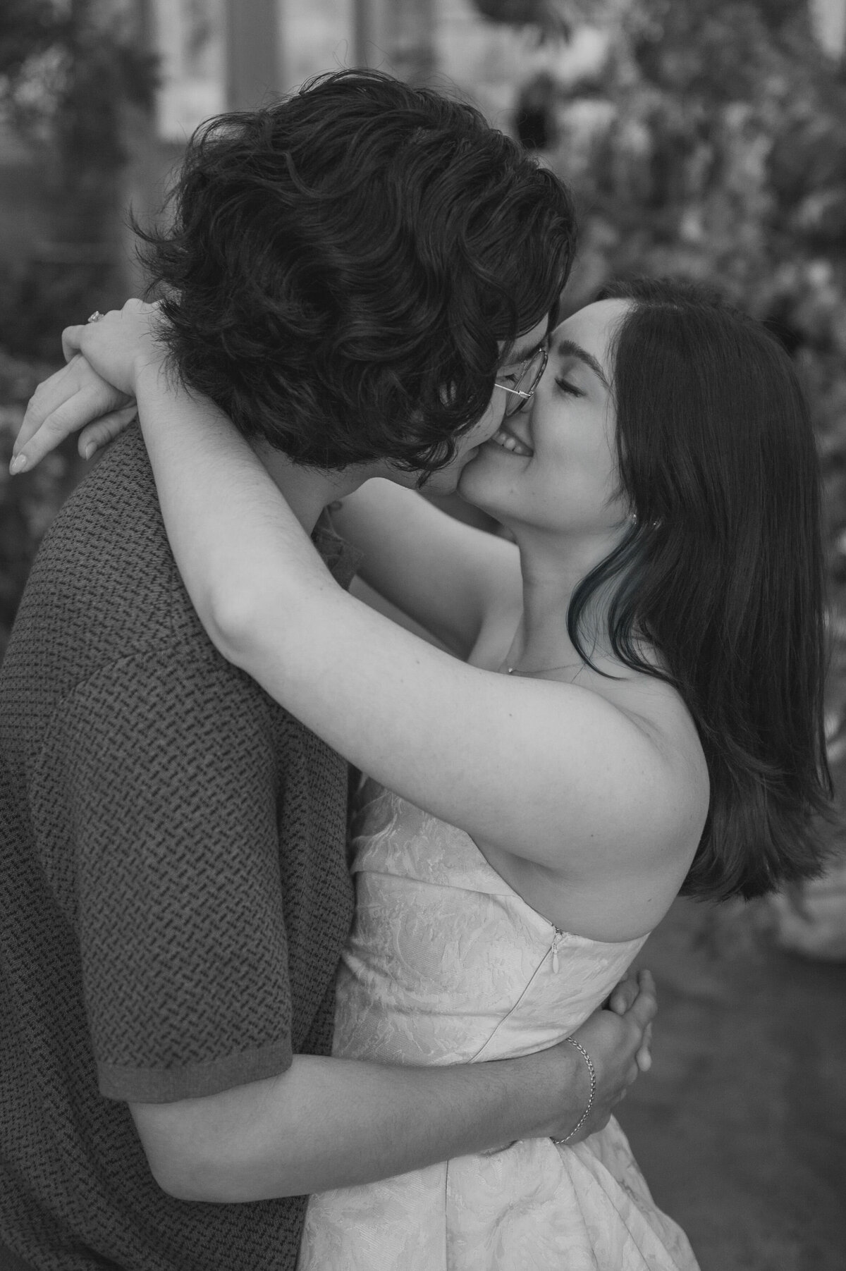 A couple leans in for a kiss at their engagement session