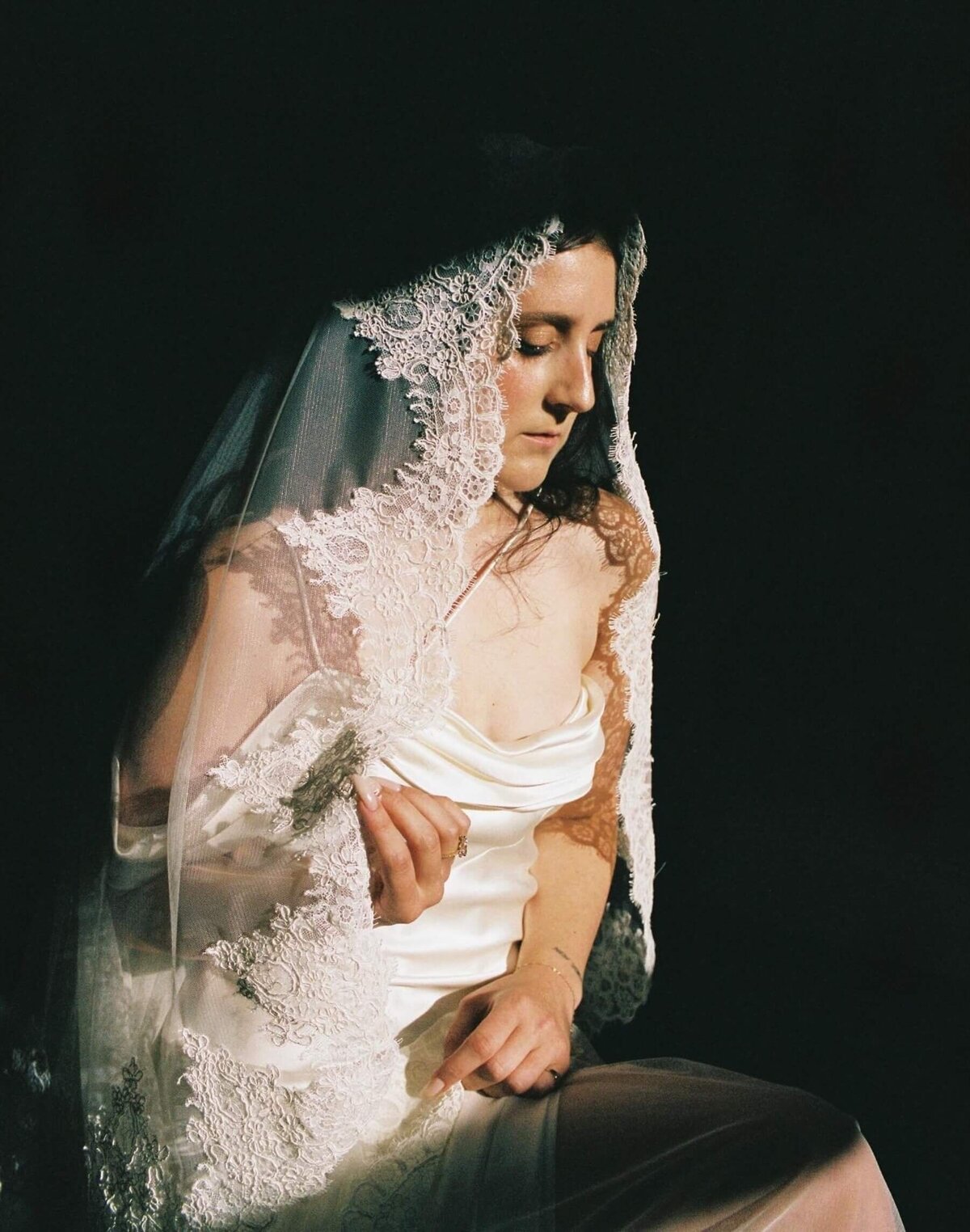 bride-in-lace-veil-silk-dress-dramatic-lighting