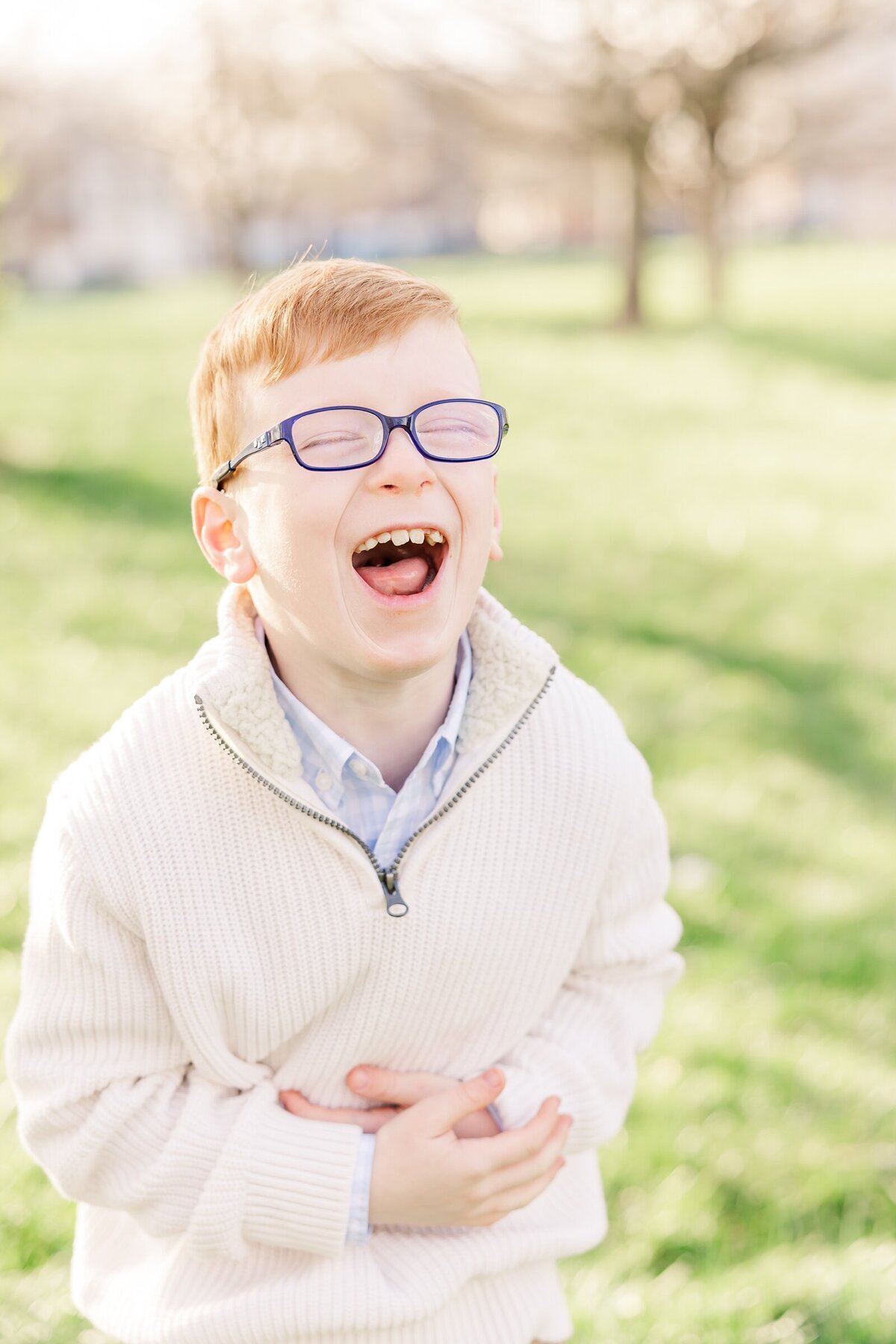 Young boy laughing with his hands on his belly