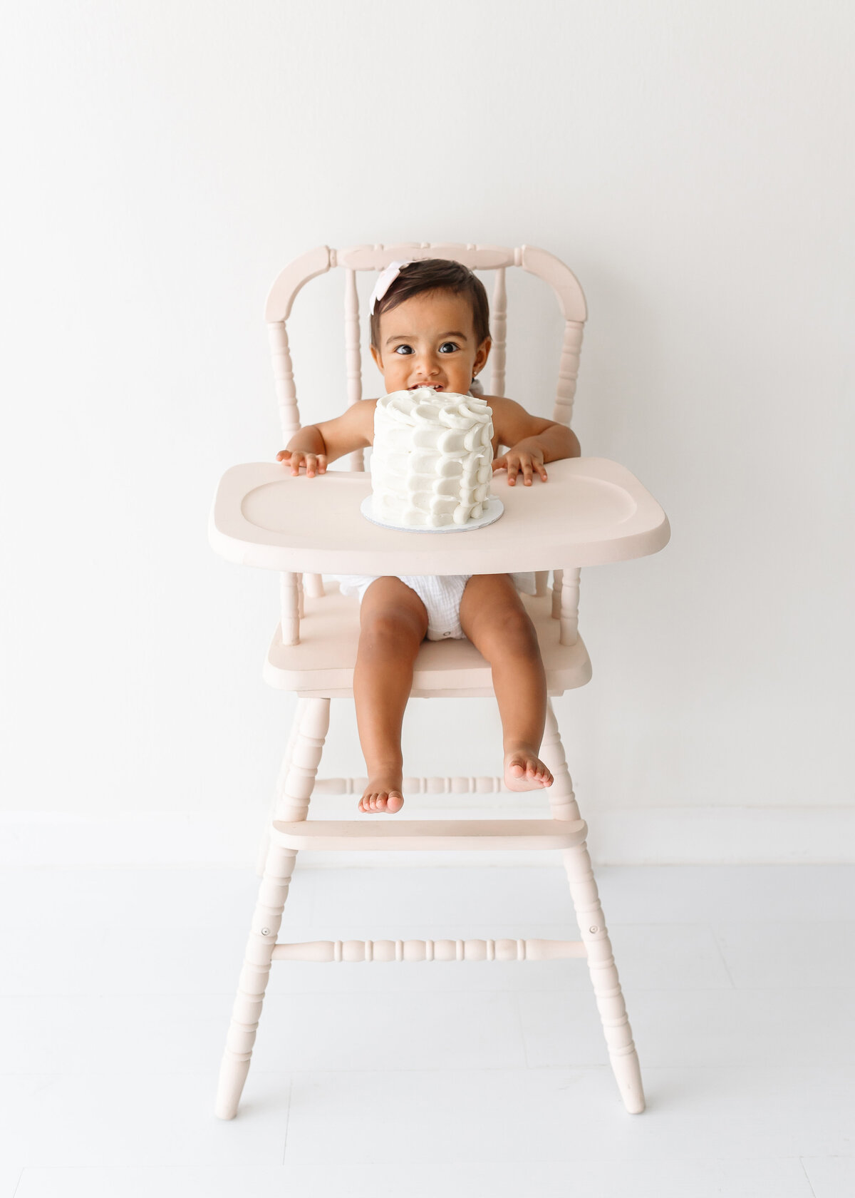 girl on high chair and cake