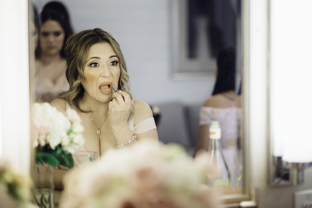 Wedding Photograph Of Woman Doing Her Lipstick In Front Of a Mirror Los Angeles