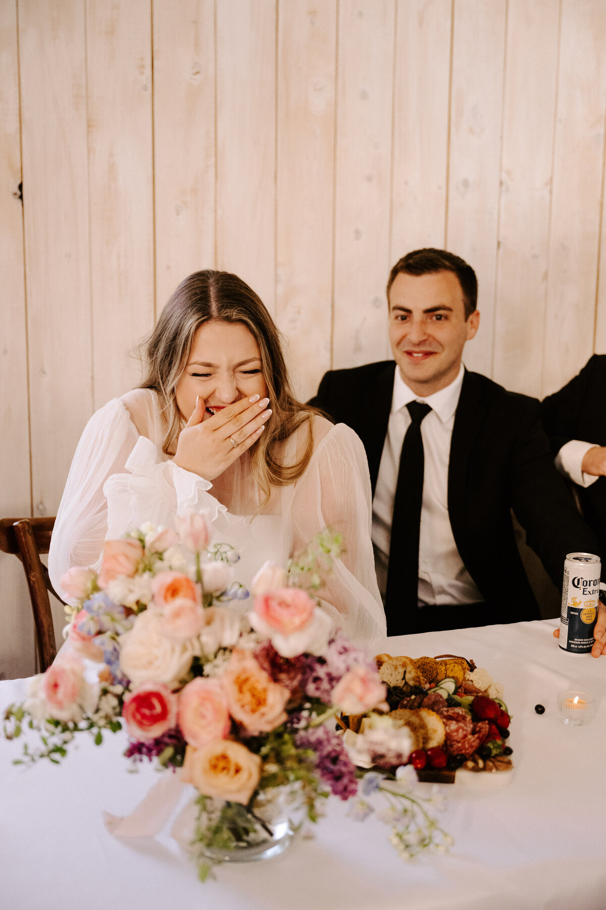 Bride laughing with groom while sitting at the head table during wedding reception the Grand Ivory near Moncton, New Brunswick