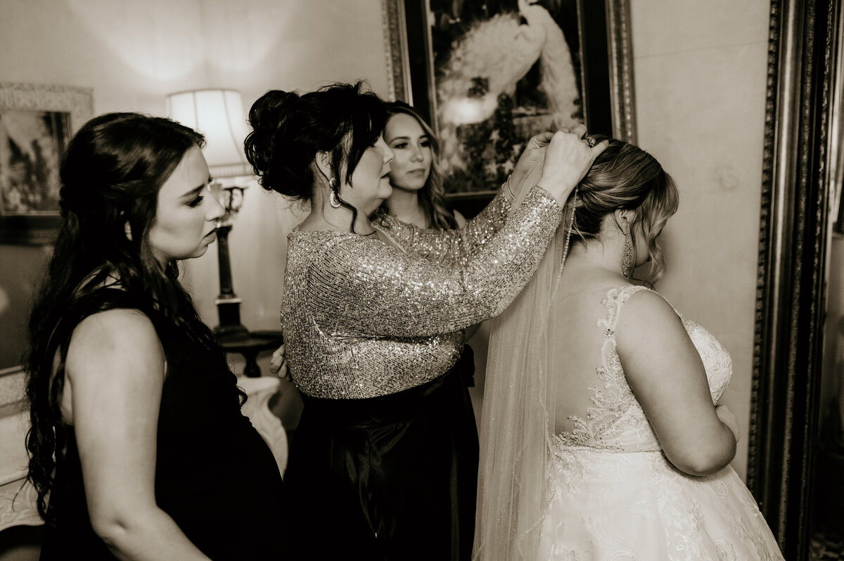 mother of the bride helping the bride with her veil as she gets ready for her little rock ar wedding