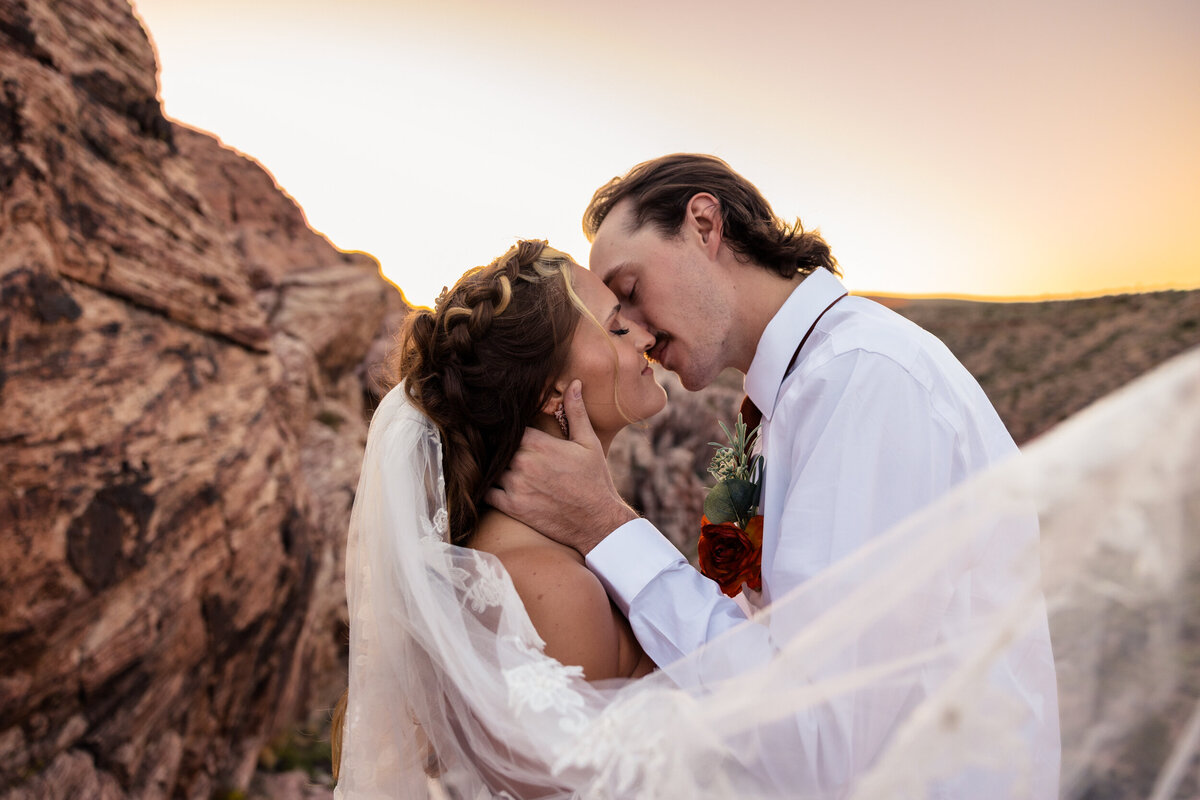 Bride and groom kissing at red rock canyon.
