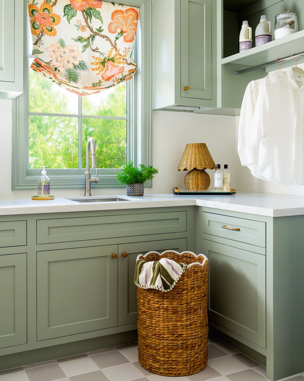 french lab designs laundry room with sink and window with solf green painted cabinets