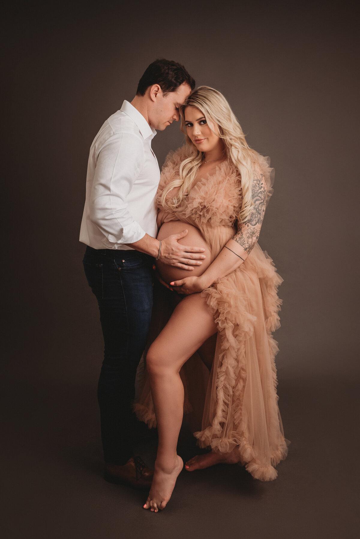 Atlanta, Georgia newborn photographer portrait session with pregnant woman at maternity session posing with husband wearing pink tulle gown