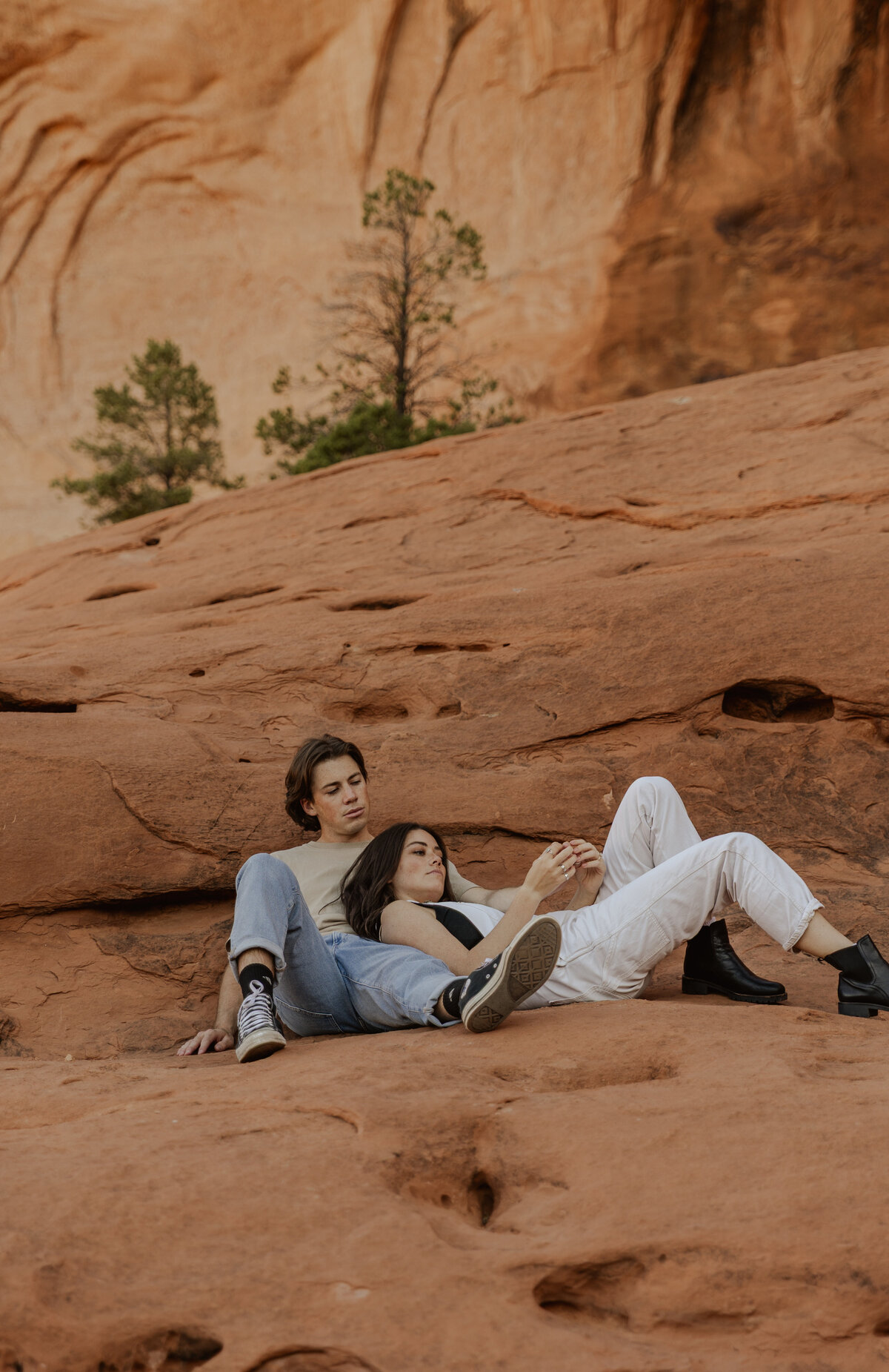 Couple laying down in the Moab, UT Desert  for photos 