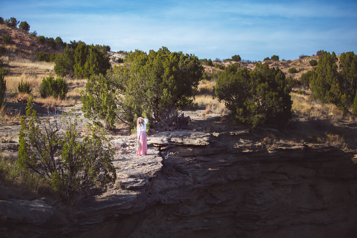 Senior girl standing on edge of canyon