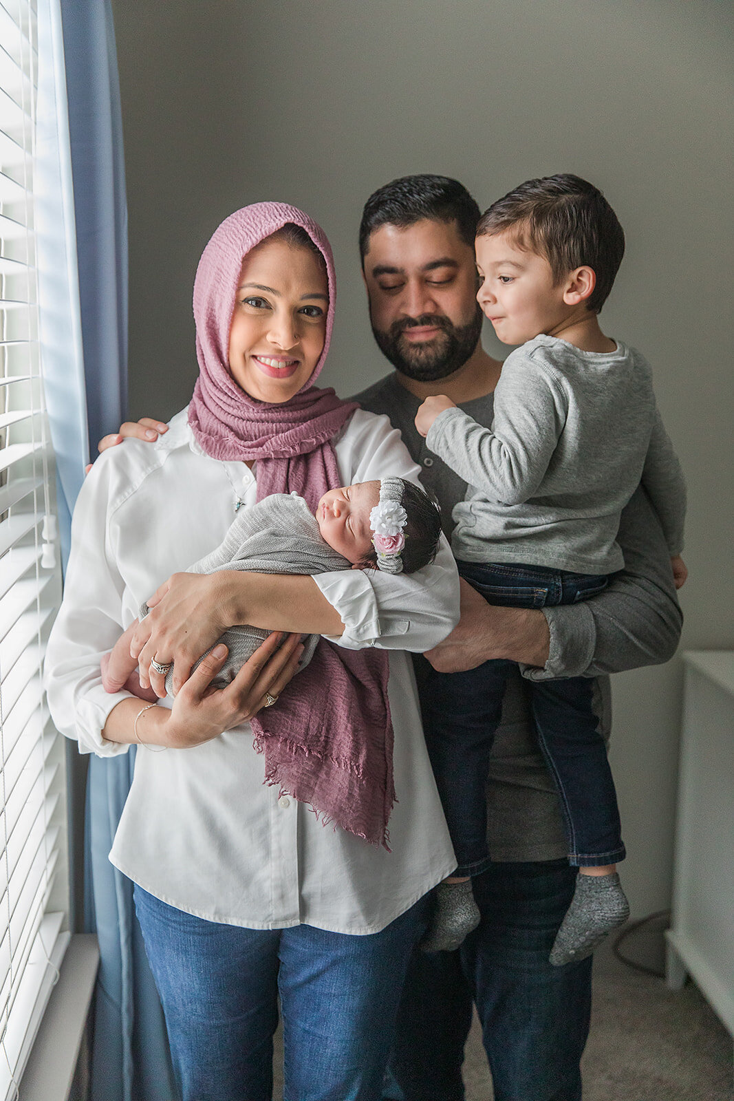 Family Poses Together with Newborn in Home Nursery