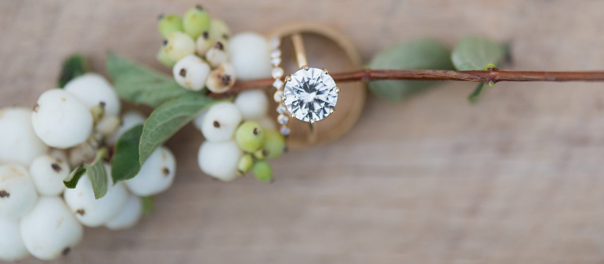 Gold Wedding Rings with white berries on wood farm table photo