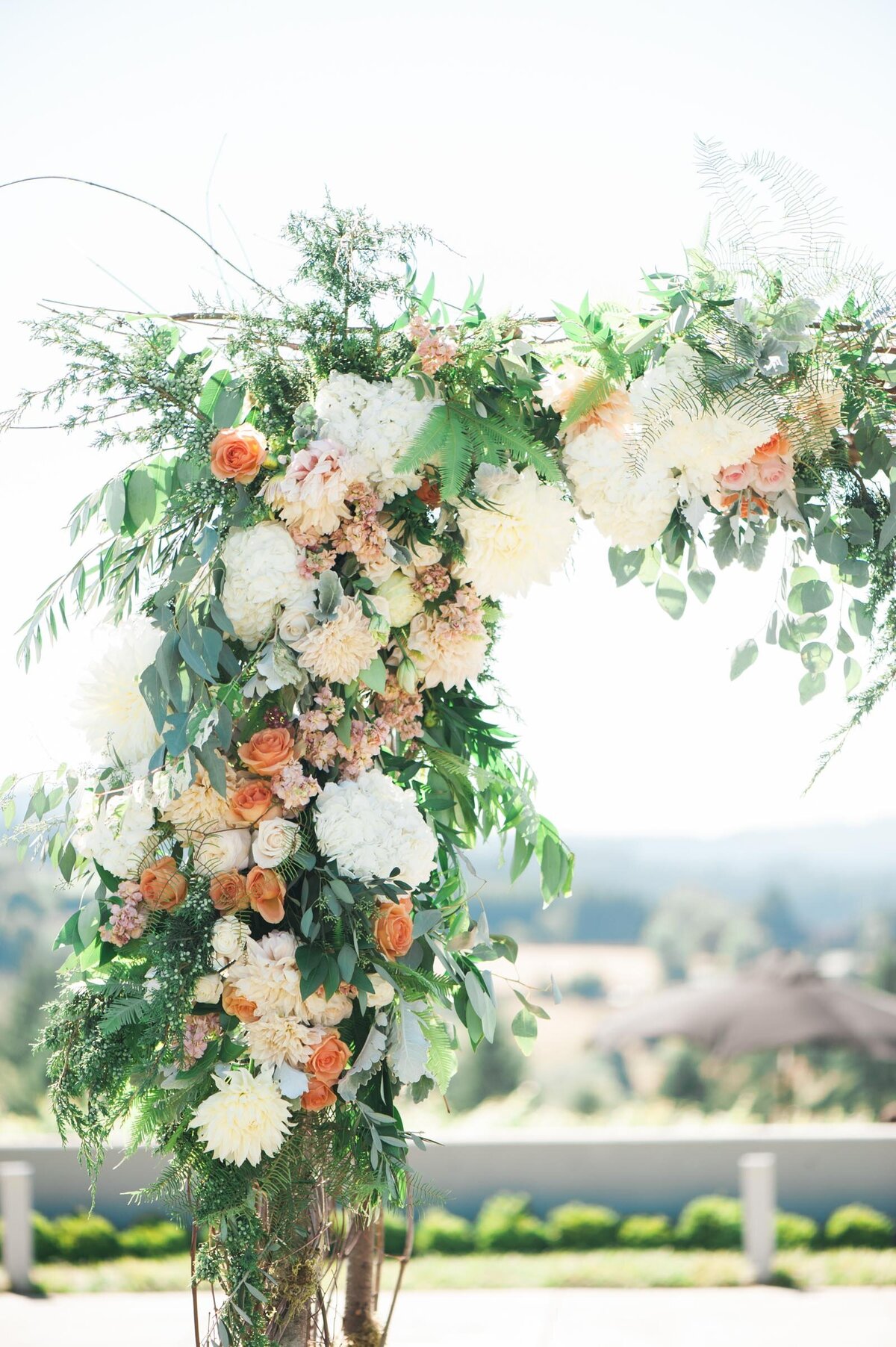 peach and white floral arbor by blum floral design at ponzi vineyard