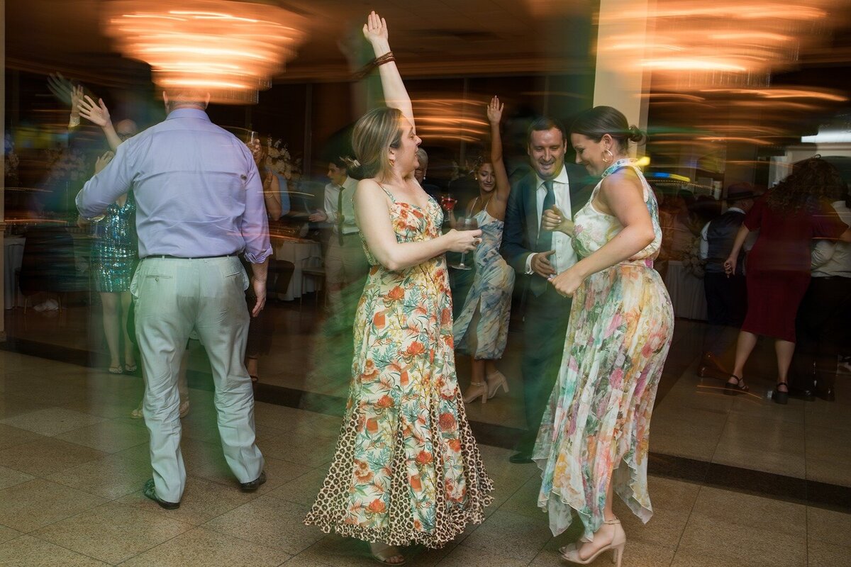 Wedding reception of guests dancing with light motion.