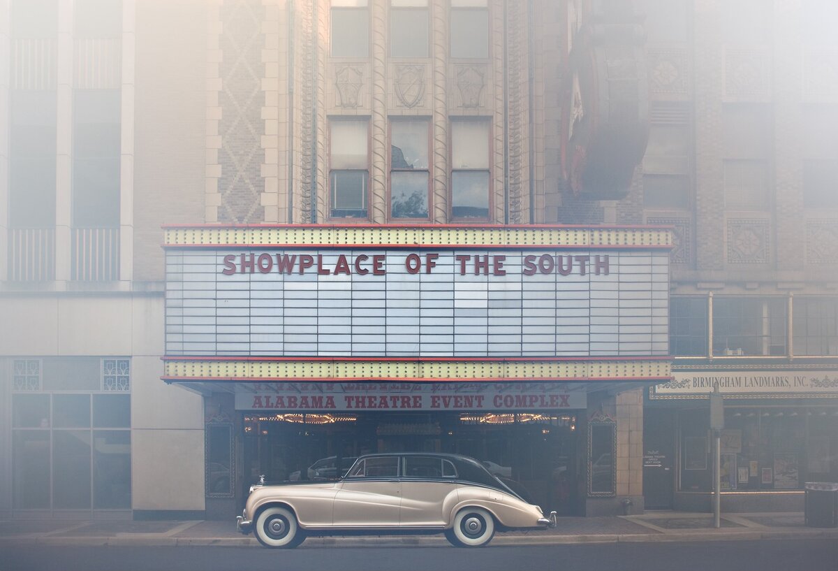 Classic Rolls-Royce parked in front of the historic Alabama Theatre.
