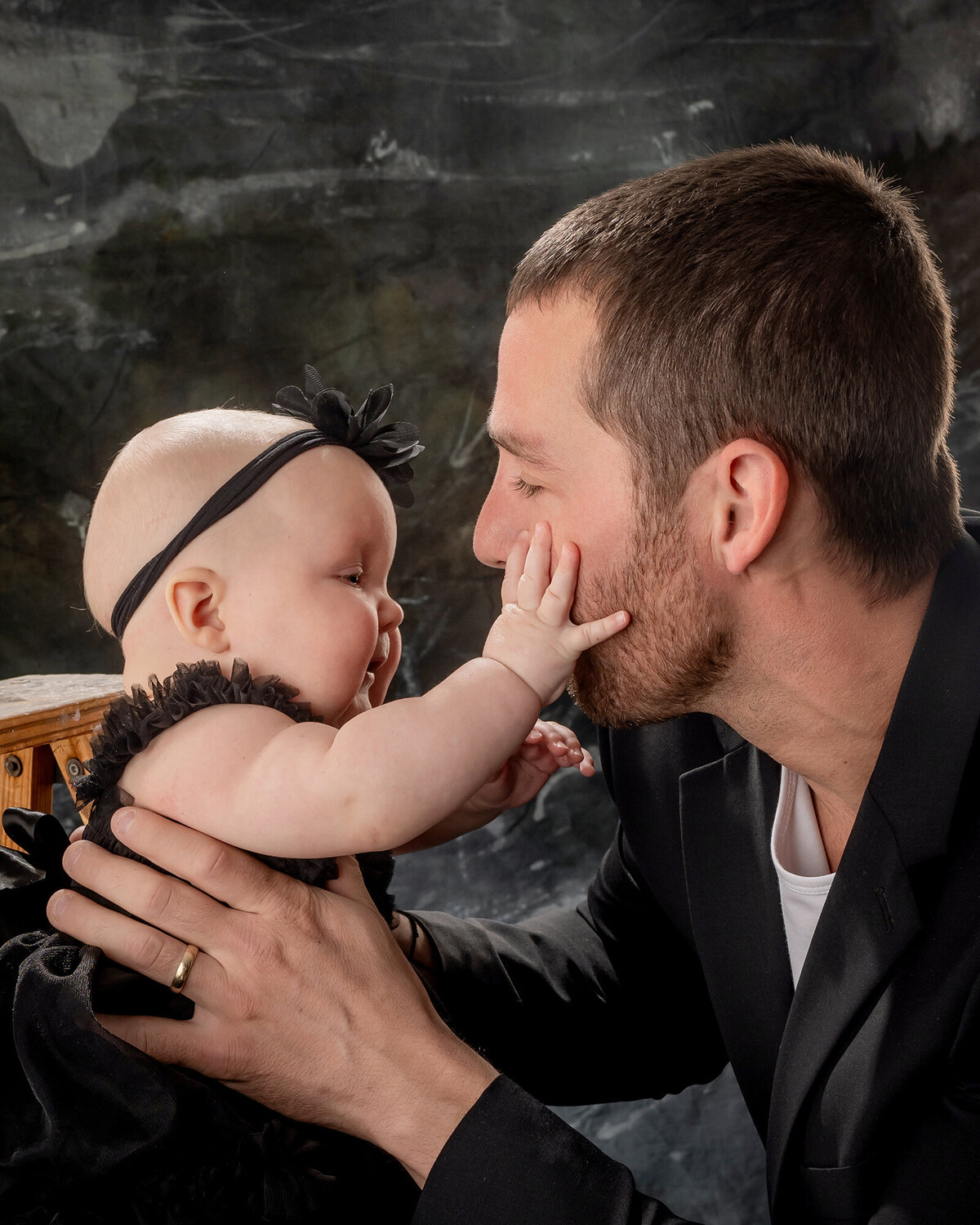 An Iowa Family Photographer captures a baby girl touching her dad’s face