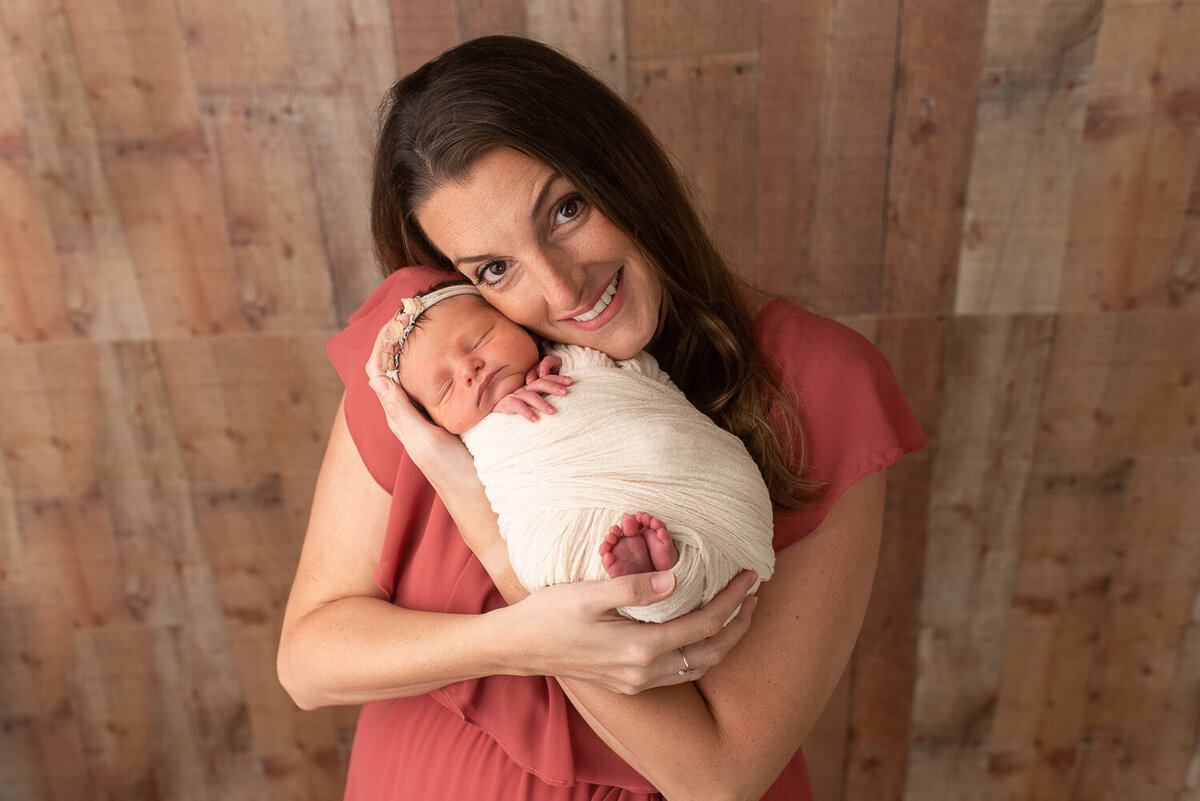 Mother holding newborn baby girl at baby studio session in Canton, CT
