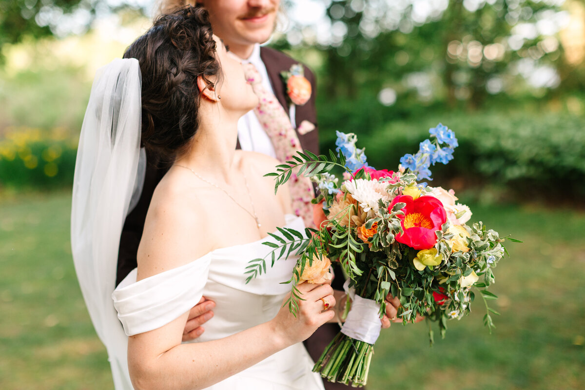 Bride and groom share a moment in the grotto at their Hermitage Museum Wedding, holding her bouquet by Virginia Beach Florist