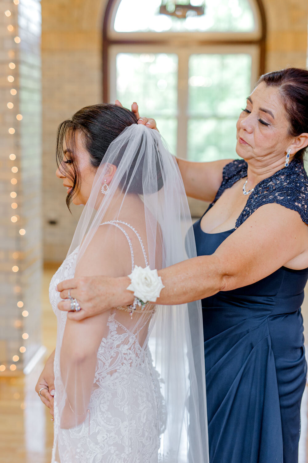 Mother helping bride with veil