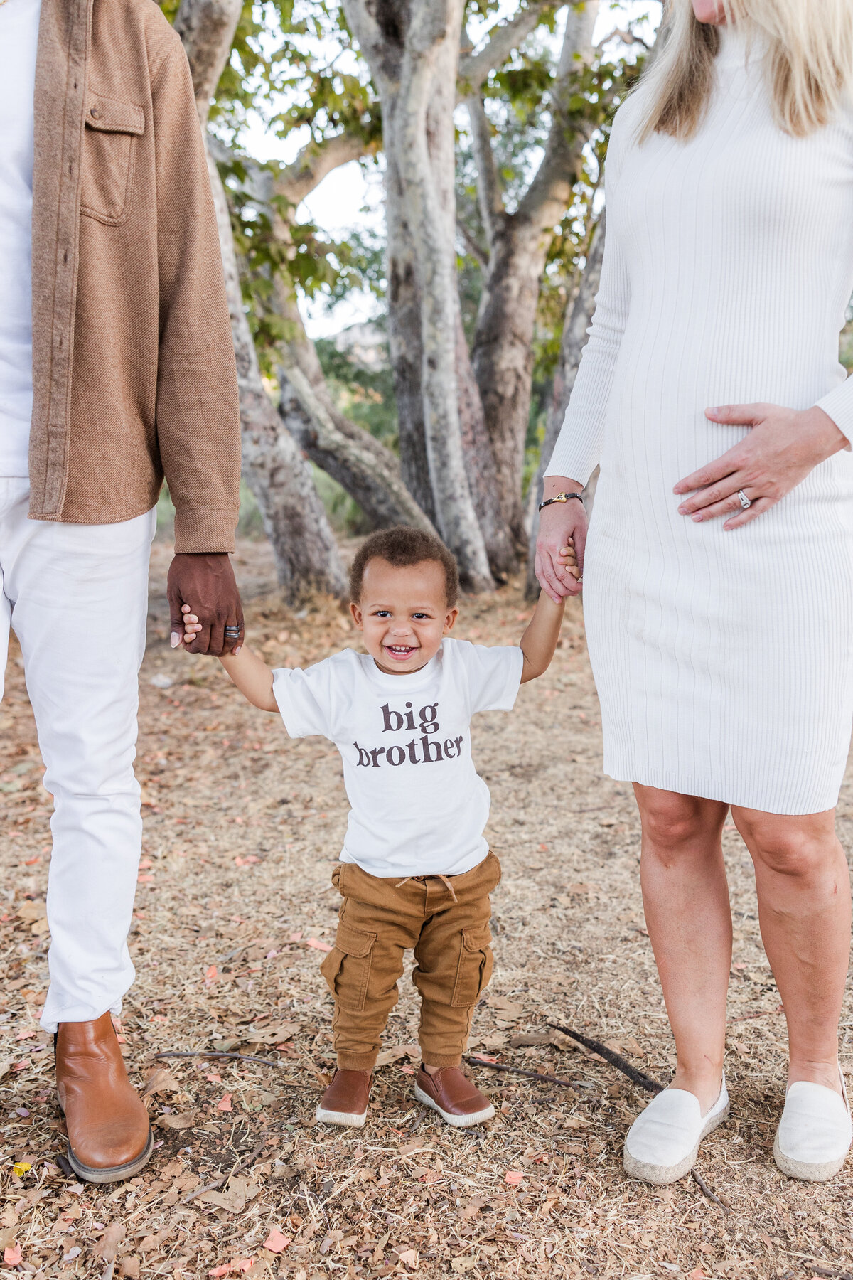 toddler holding his parents hands