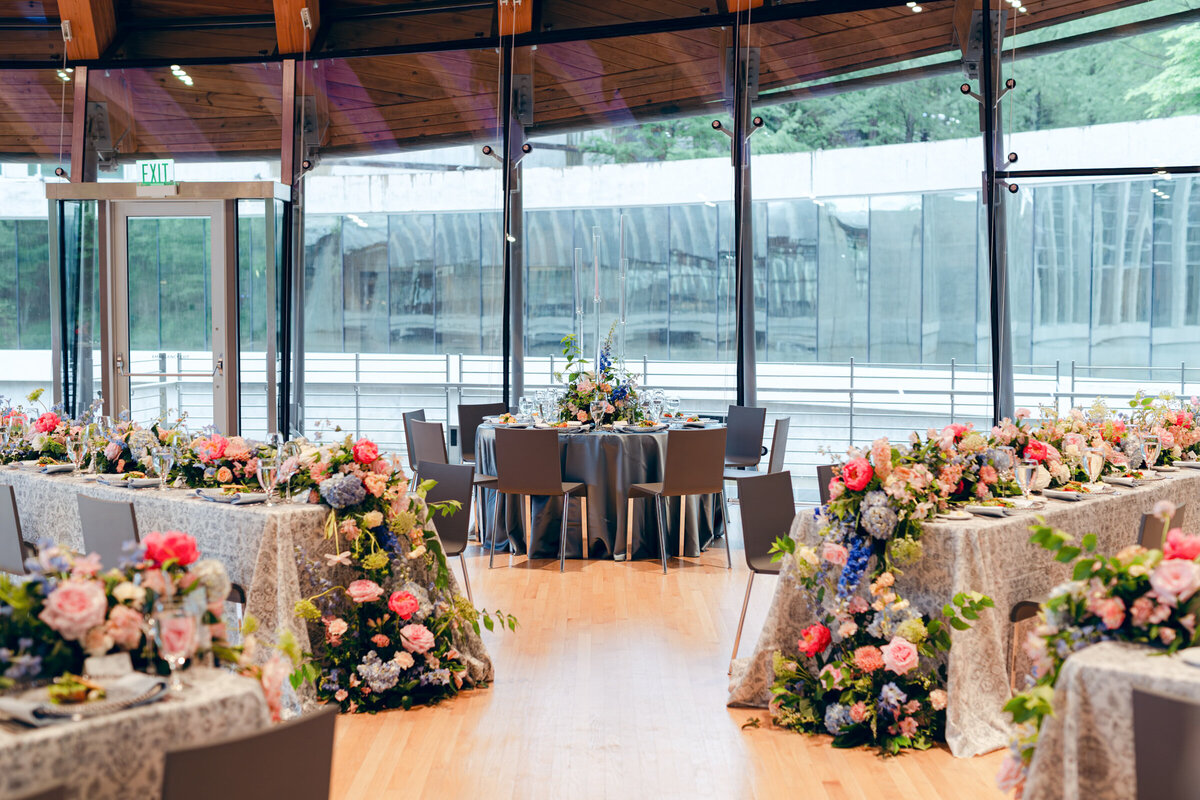 A wedding day photo of the recpetion area covered in florals, candles and linens at Crystal Bridges Museum of American Art