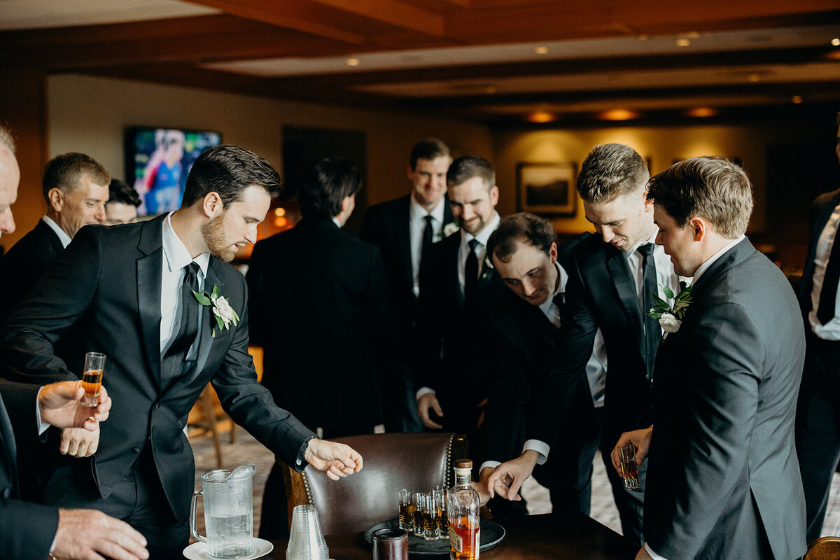 Groom and groomsmen pouring shots