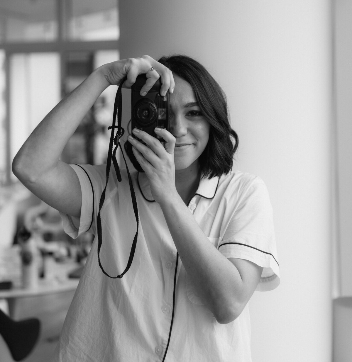 Bride holding a camera taking pictures while she gets ready