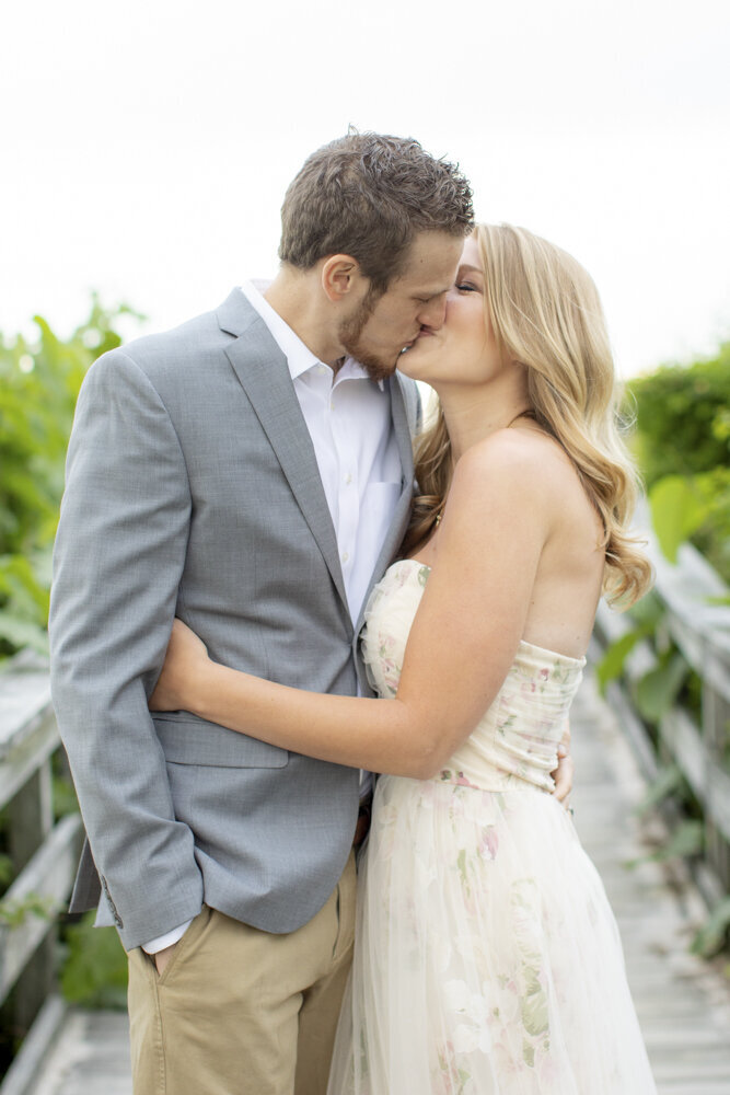 couple kisses for engagement photo
